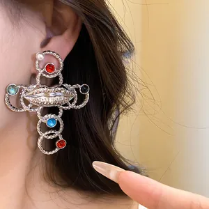 Vintage silver-tone cross earrings featuring a resin lip motif and colorful stones detail