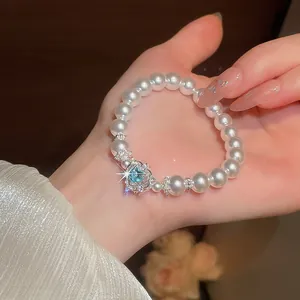 Detailansicht eines französischen Vintage-Perlenarmbands mit einem blauen Herz-Edelstein.