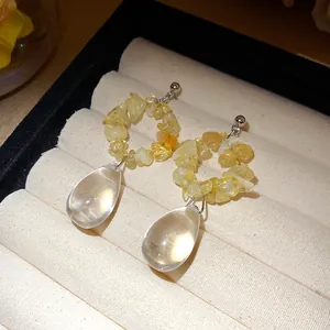 Primo piano di orecchini vintage in pietra gialla con pendenti a goccia d'acqua