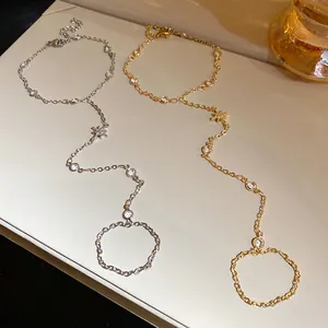 Close-up of gold and silver star chain bracelet-ring combo with sparkling zircons