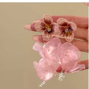 Detail of pink beaded flower earrings with tassel and organza petals