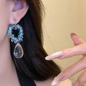 Primo piano di orecchini vintage a goccia d'acqua con pietre blu e pendente chiaro