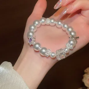 Detailaufnahme eines eleganten Perlenarmbands im französischen Stil mit Schleife und Kristall