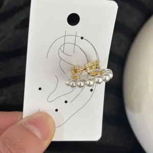 Elegant gold ear cuff with white pearls and crystals on ear display card