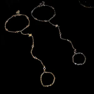 Detail view of gold and silver star slave bracelets with zircon on black background