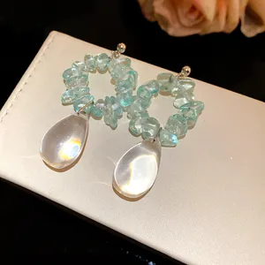 Dettaglio orecchini vintage con pietre blu irregolari e grandi pendenti a goccia