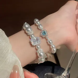 Detailansicht von Perlenarmbändern im französischen Stil mit Herz- und Kristallanhängern