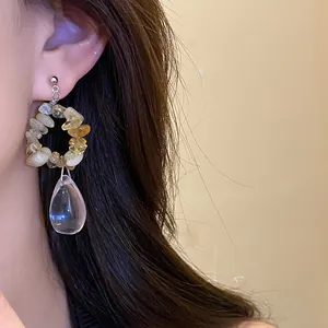 Dettaglio di orecchini vintage in argento con pietre irregolari e pendente a goccia