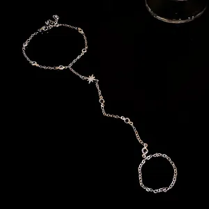 Detailed view of silver star slave bracelet featuring sparkling zircon stones on black background.
