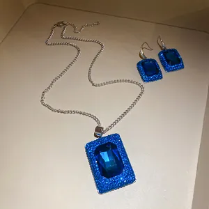Detailansicht eines luxuriösen funkelnden blauen rechteckigen Anhänger- und Ohrring-Sets