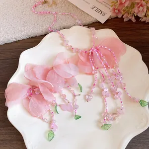 Vue détaillée du collier de fleurs à pampilles en perles roses avec de doux pétales en tissu