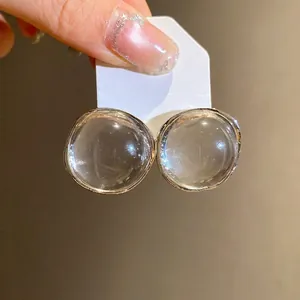 Minimalist transparent round resin stud earrings with elegant gold-tone rim design.