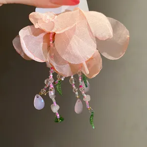Détail du collier à pampilles en fleurs roses perlées avec pétales de mousseline
