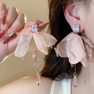 Detail of elegant pink chiffon flower earrings with zircon and glass teardrop tassels.