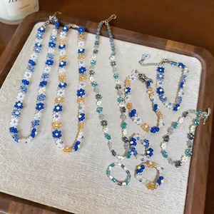 Handmade flower beaded jewelry set including necklaces, bracelets, and rings.