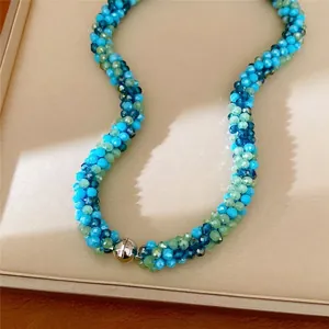 Collier en perles de verre torsadées avec fermoir magnétique argenté.