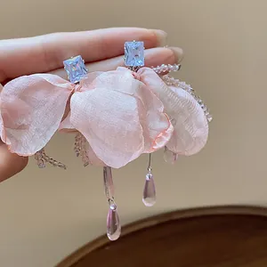 Close-up of pink chiffon flower tassel earrings with blue zircon studs