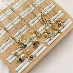 Colliers dorés avec pendentifs sur le thème du voyage avion globe et tour Eiffel