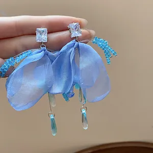 Close-up of blue chiffon flower earrings with water drop tassels and zircon studs