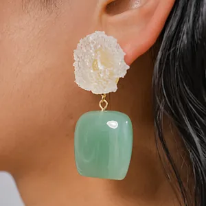 Primer plano de pendientes de flores de resina con colgante cuadrado verde translúcido