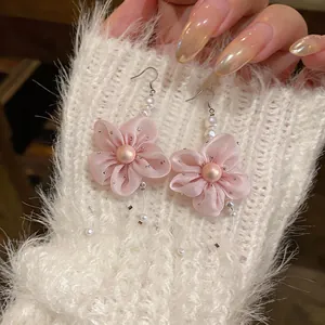 Close-up of elegant pink chiffon flower earrings featuring pearls and silver accents.