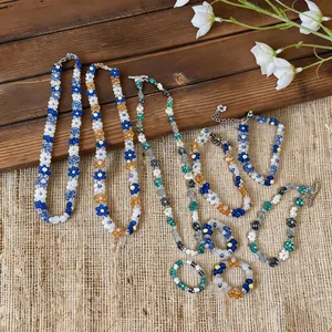 Colorful handmade beaded flower jewelry set including necklaces, bracelets, and rings
