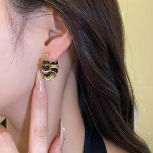 Elegant vintage geometric hoop earrings with resin beads and gold accents worn by a model