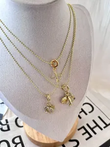 Détail de colliers voyage spatial plaqués or avec pendentifs avion et célestes
