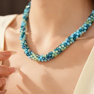 Gros plan d'un collier de perles de verre tressées bleues et vertes sur un mannequin