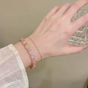 Elegant rose gold bracelet featuring multi-colored square zircons worn by an Asian model