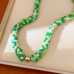 Détail d'un collier artisanal en perles de verre vert avec fermoir magnétique argenté