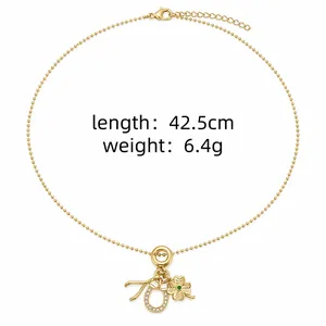 Détail du collier plaqué or avec des pendentifs trèfle à quatre feuilles et fer