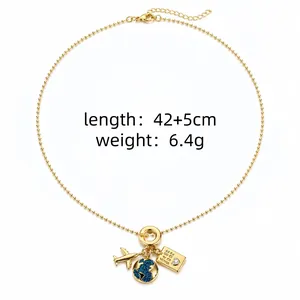 Vue détaillée d'un collier plaqué or orné de breloques avion et globe terrestre