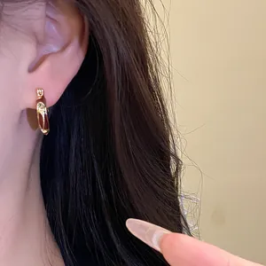 Close-up detail of a vintage style gold hoop earring with brown drip oil resin finish