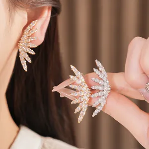 Detail view of luxury 18k gold plated wing-shaped clip-on earrings with shimmering zircons