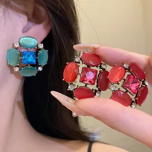 Primo piano di orecchini vintage di lusso occhio di gatto con strass in rosso e blu