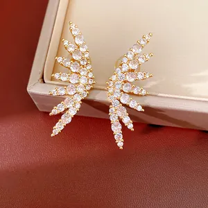 Close-up detail of 18k gold plated wing clip-on earrings with cubic zirconia stones