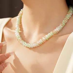 Vue détaillée d'un collier ras du cou en perles de verre avec des perles vertes et champagne