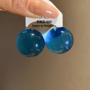 Dettaglio orecchini a lobo minimalisti in resina blu traslucida con ago in argento 925