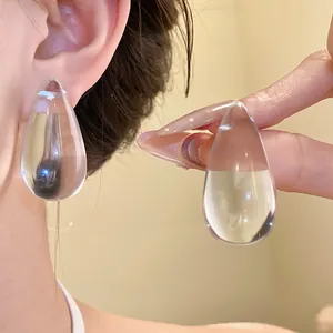 Dettaglio di orecchini a goccia in resina trasparente con eleganti perni in argento s925