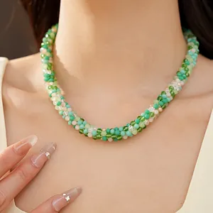 Vue détaillée d'un collier de perles en verre vert et blanc pour l'été sur un mannequin.