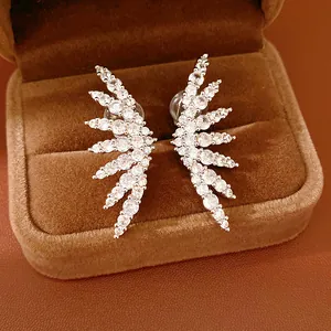 Close-up of elegant wing-shaped clip-on earrings with sparkling cubic zirconia
