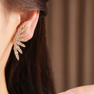 Close-up of a gold-plated wing ear cuff with sparkling cubic zirconia on model
