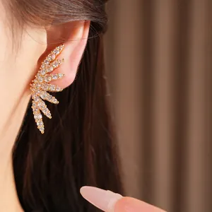 Detailed macro view of a sparkling zirconia wing-shaped ear cuff with 18k gold plating