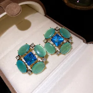 Dettaglio degli orecchini vintage in stile reale con cristallo blu e occhio di gatto
