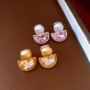 Close-up of vintage semi-circular crystal clip-on earrings in gold and silver finishes
