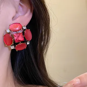 Primo piano di orecchini vintage stile palazzo con pietre rosse e cristalli