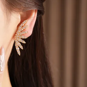 Close-up of sparkling 18k gold plated wing ear cuff with cubic zirconia inlay