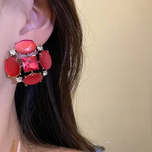 Primo piano di orecchini vintage in stile corte con occhio di gatto rosso e strass