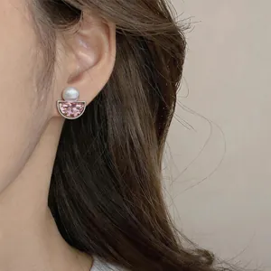 Close-up of elegant French vintage pink crystal ear clips with white pearl detail